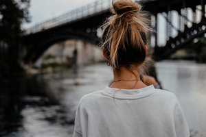 Young woman on a riverfront with her hair in a bun